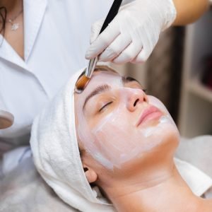 beautician-with-brush-applies-white-moisturizing-mask-face-young-girl-client-spa-beauty-salon-1-scaled.jpg