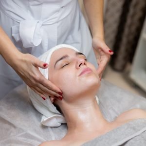 young-beautiful-girl-lies-beautician-s-table-receives-procedures-light-facial-massage-using-oil-2-scaled.jpg