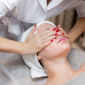 young-beautiful-girl-lies-beautician-s-table-receives-procedures-light-facial-massage-using-oil-scaled.jpg